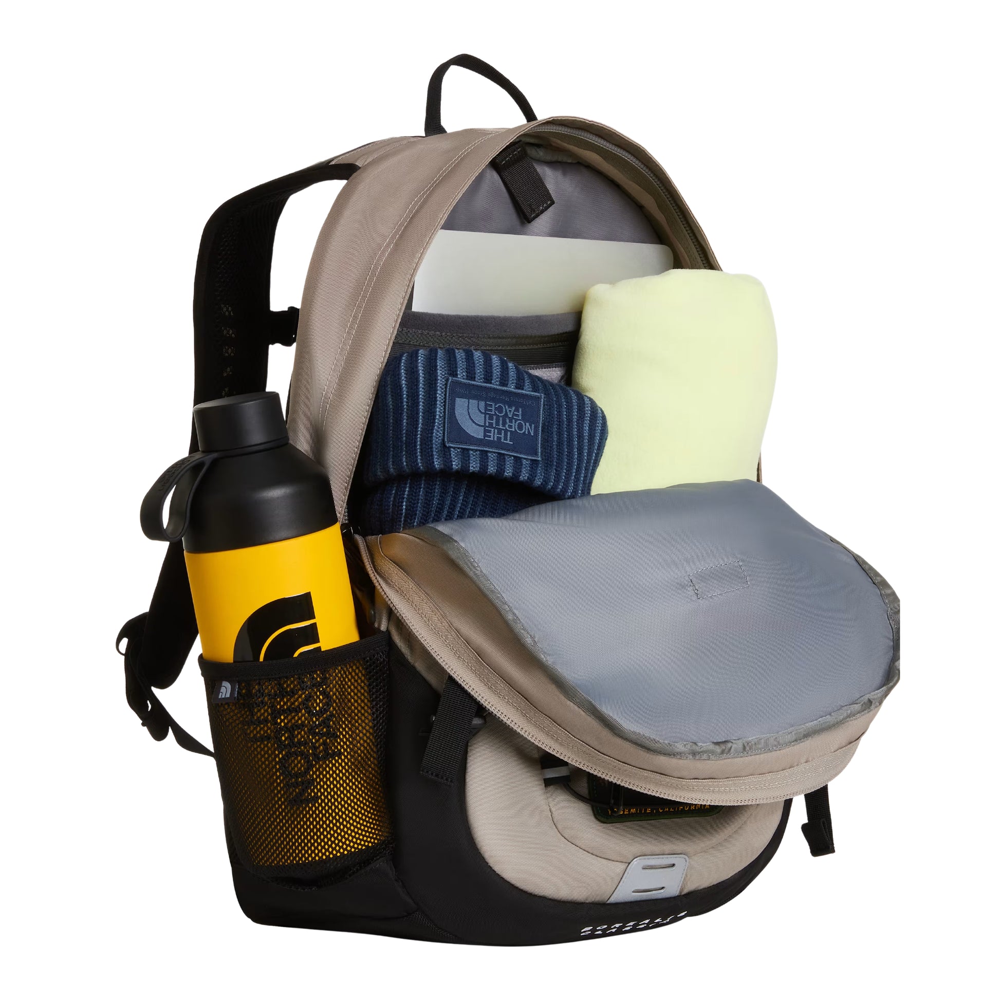 Mochila The North Face Borealis Classic Patch em Stone Slab / TNF Black — interior aberto com compartimento principal, laptop branco, sweat TNF azul, garrafa preta/amarela no bolso lateral em malha e bolso organizador cinzento visíveis.