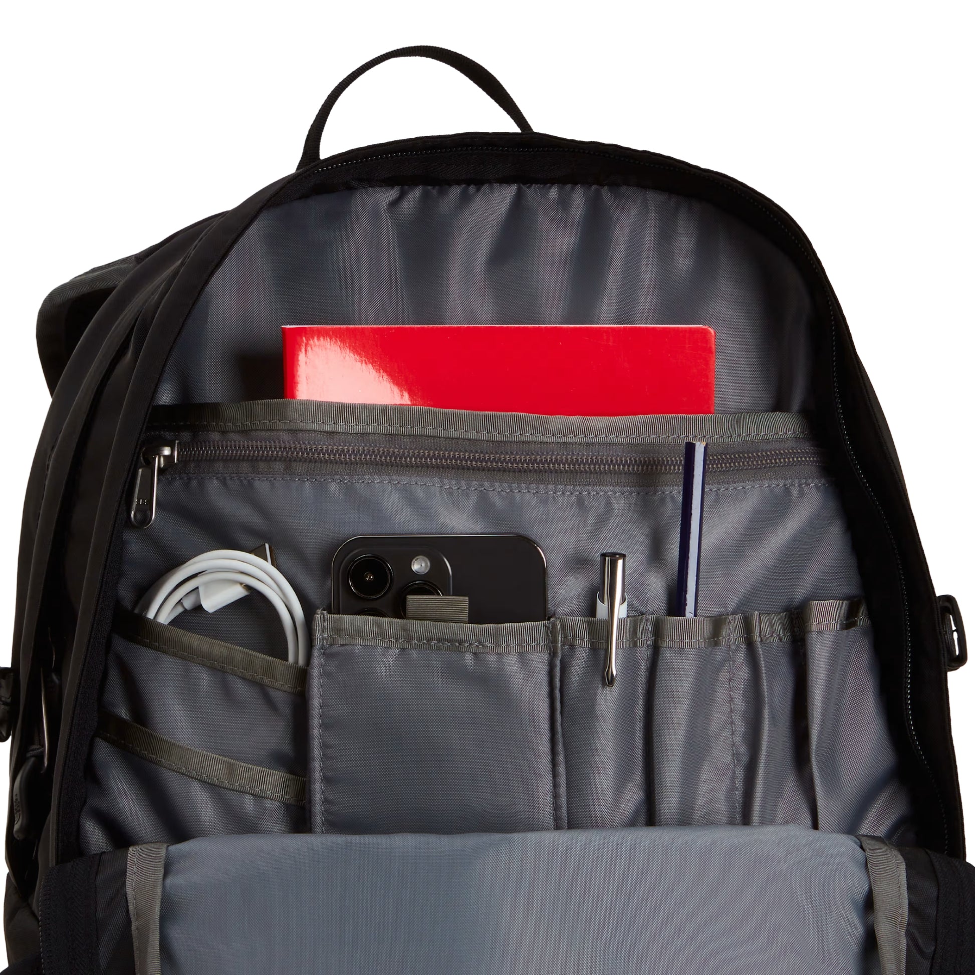 Mochila The North Face Borealis Classic Patch em TNF Black — interior do bolso frontal aberto em Asphalt Grey, com bolso para smartphone preto, porta-cabos, porta-canetas e caderno vermelho visíveis.