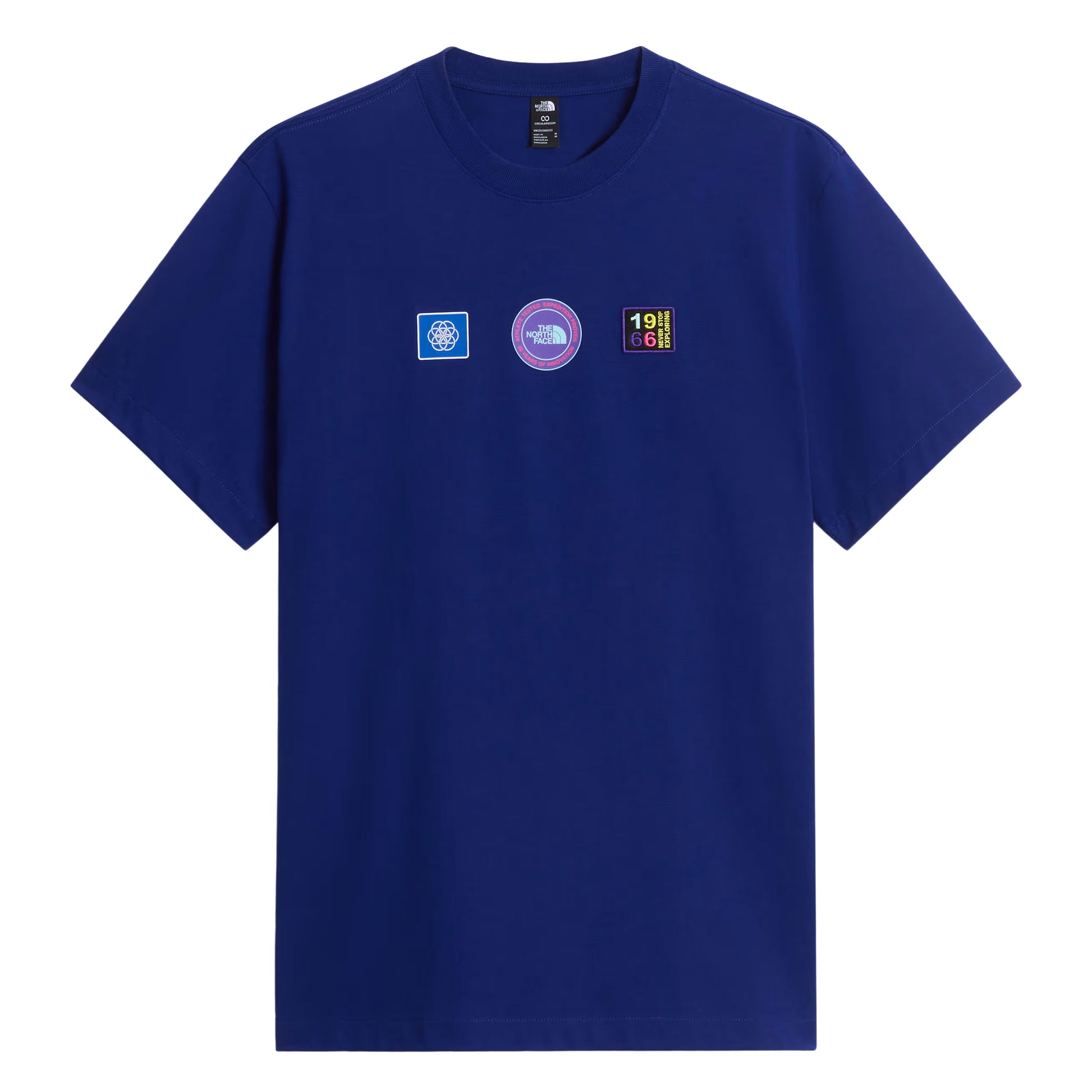 T-shirt unissexo The North Face Explorer Badges Relaxed em Bold Blue — vista frontal, produto sem modelo, três emblemas Explorer estampados em serigrafia à base de água no peito (azul quadrado com globo, circular roxo "The North Face", retangular escuro "1966 Never Stop Exploring" multicolor), etiqueta TNF na gola interior visível, gola canelada e jersey Bold Blue 220 g/m² visíveis, fundo branco.