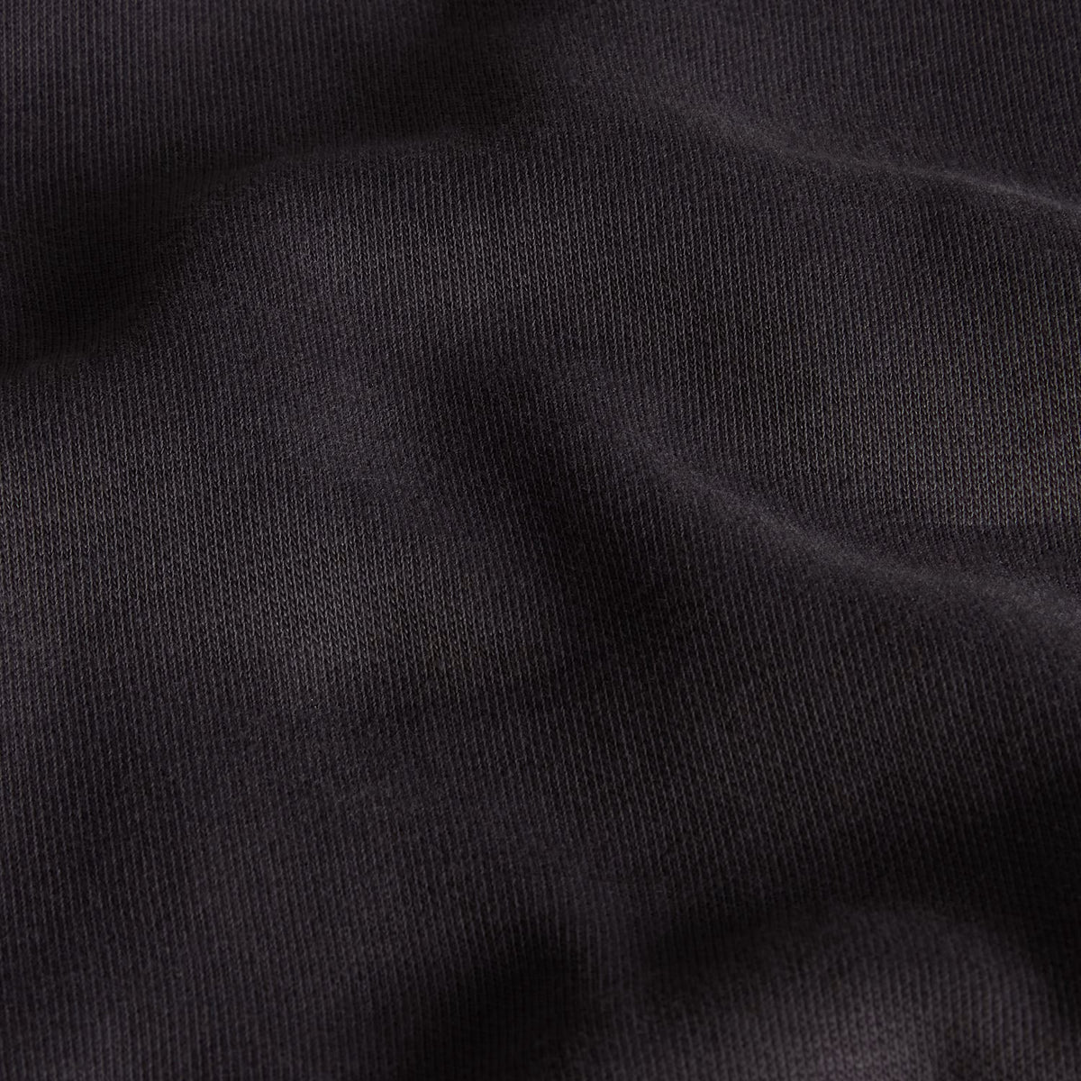 Sweatshirt unissexo The North Face Gear Up Get Out Relaxed Crew em Anthracite Grey — pormenor da textura do tecido em close-up, malha polar cinzento antracite com interior cardado visível nas dobras, sem modelo, fundo antracite.