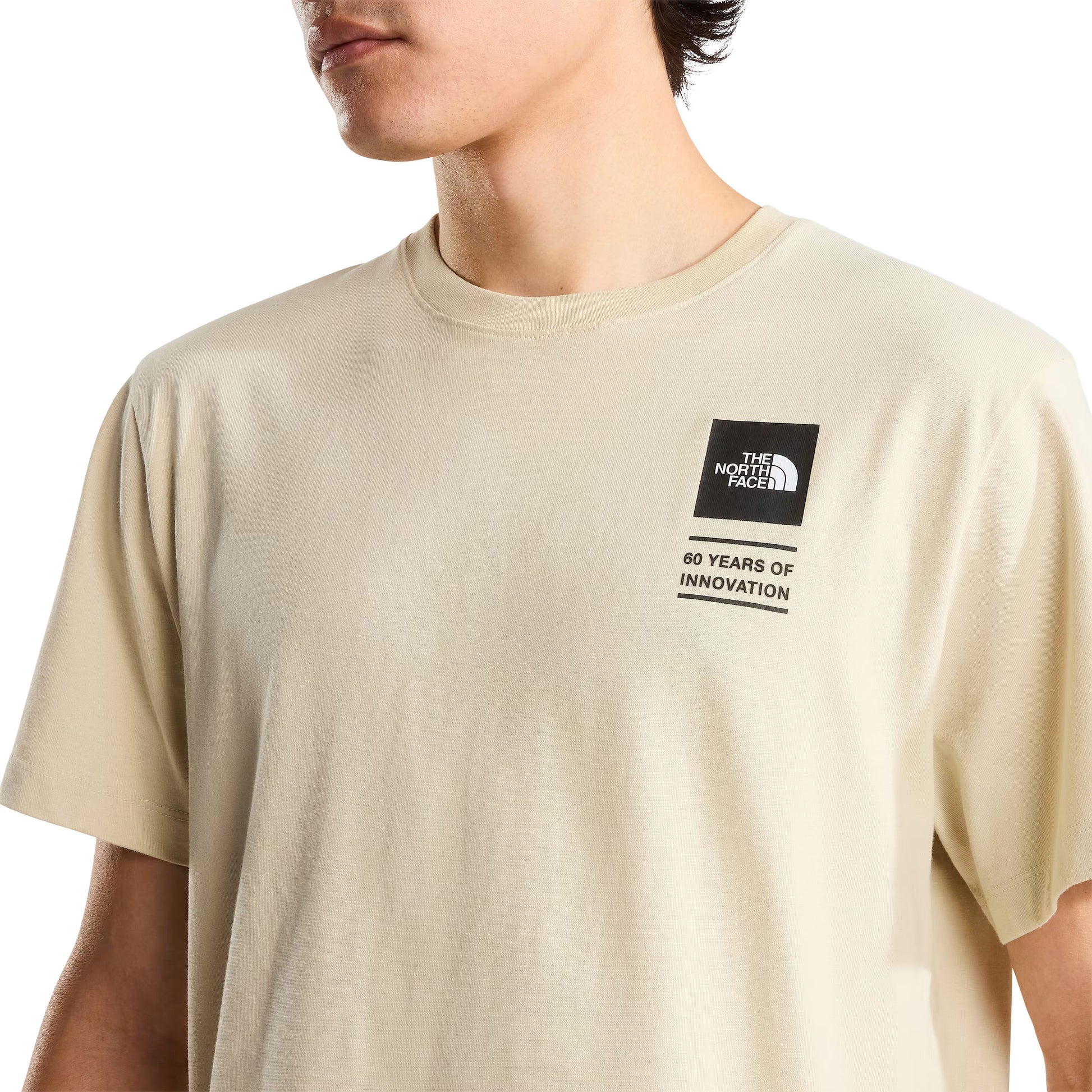 T-Shirt de manga curta para homem The North Face Icon Celebration Regular em Desert Stone. Foto de detalhe da parte da frente, vestida.