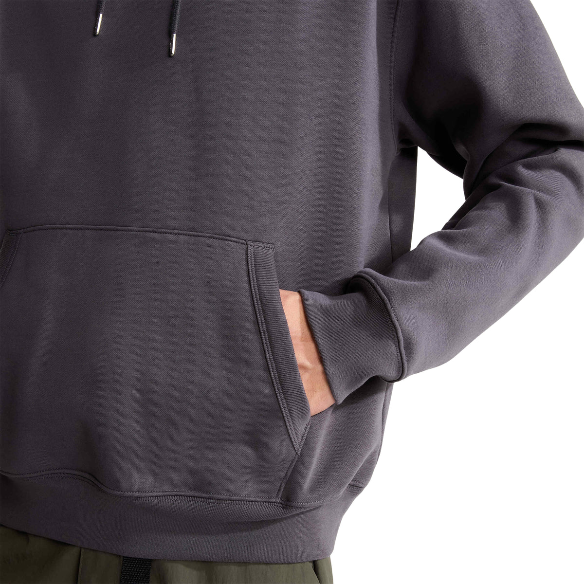 Detalhe da mão no bolso canguru com abertura canelada da sweat The North Face NSE Slopes cinzenta antracite.