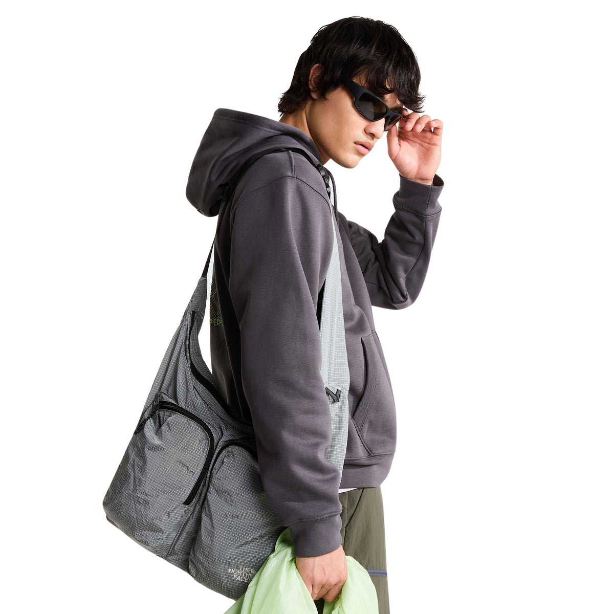 Sweat The North Face NSE Slopes em Anthracite Grey, vestida de lado com bolsa cinzenta ao ombro.