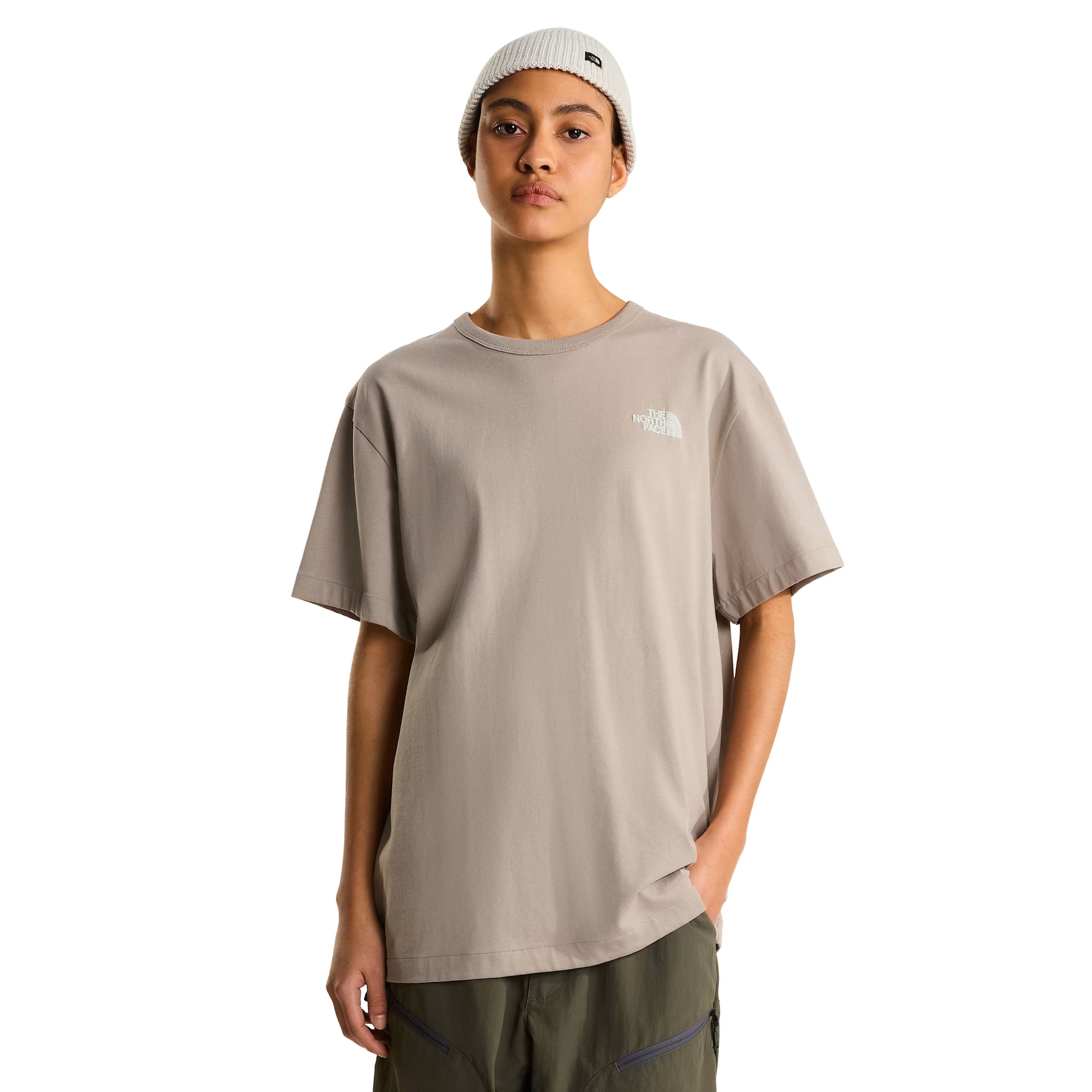 T-shirt The North Face NSE Slopes Relaxed em stone slab — modelo feminino de frente, meio corpo, corte relaxed oversized, logótipo The North Face bordado a branco no peito esquerdo, gola redonda canelada, gorro canelado branco com etiqueta TNF, fundo branco.