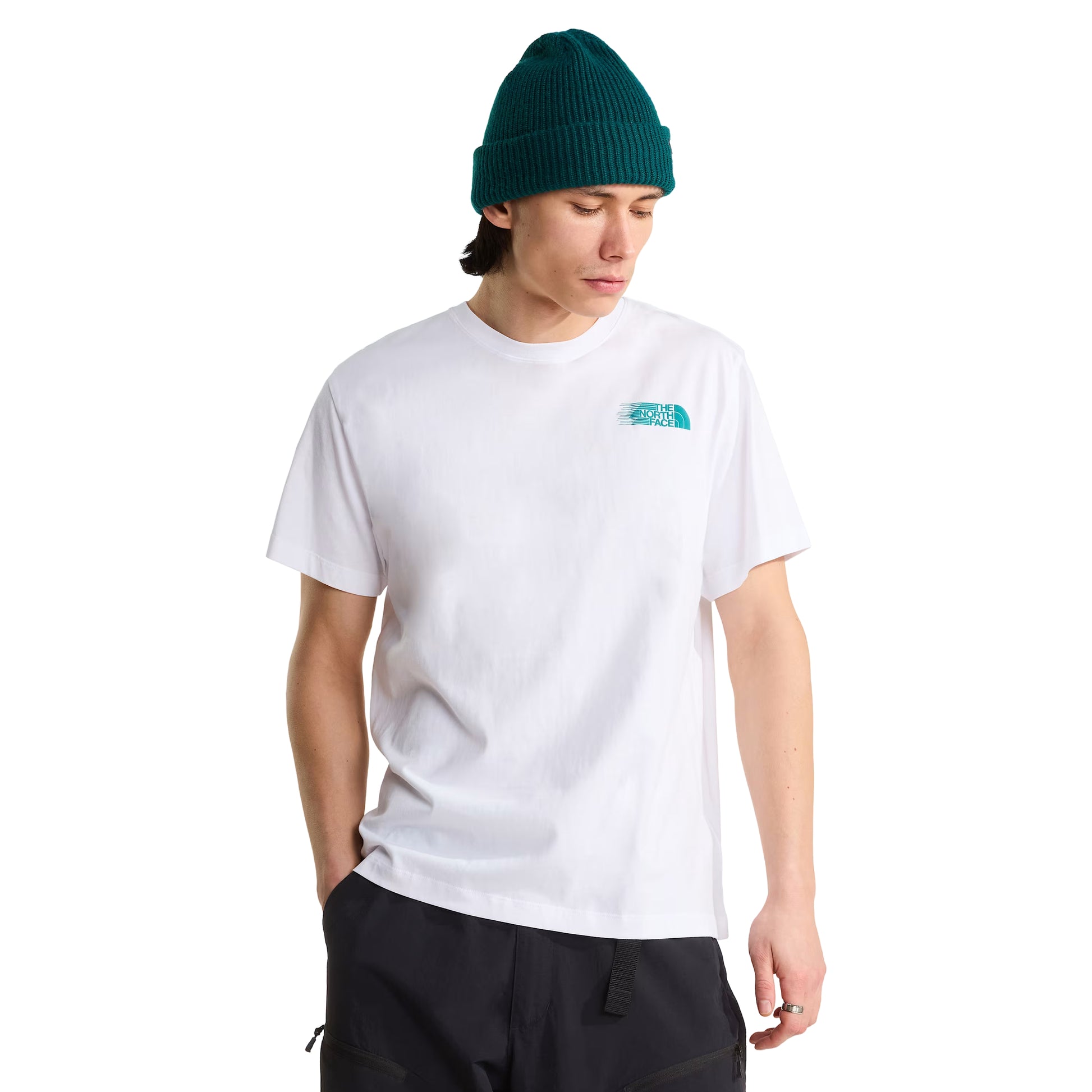 T-Shirt The North Face Retro Trail Relaxed em TNF White — modelo masculino de frente, gorro TNF verde-teal, calças pretas, logo TNF Retro Trail em teal/azul-petróleo no peito direito e gola canelada visíveis, corte relaxed, fundo branco.