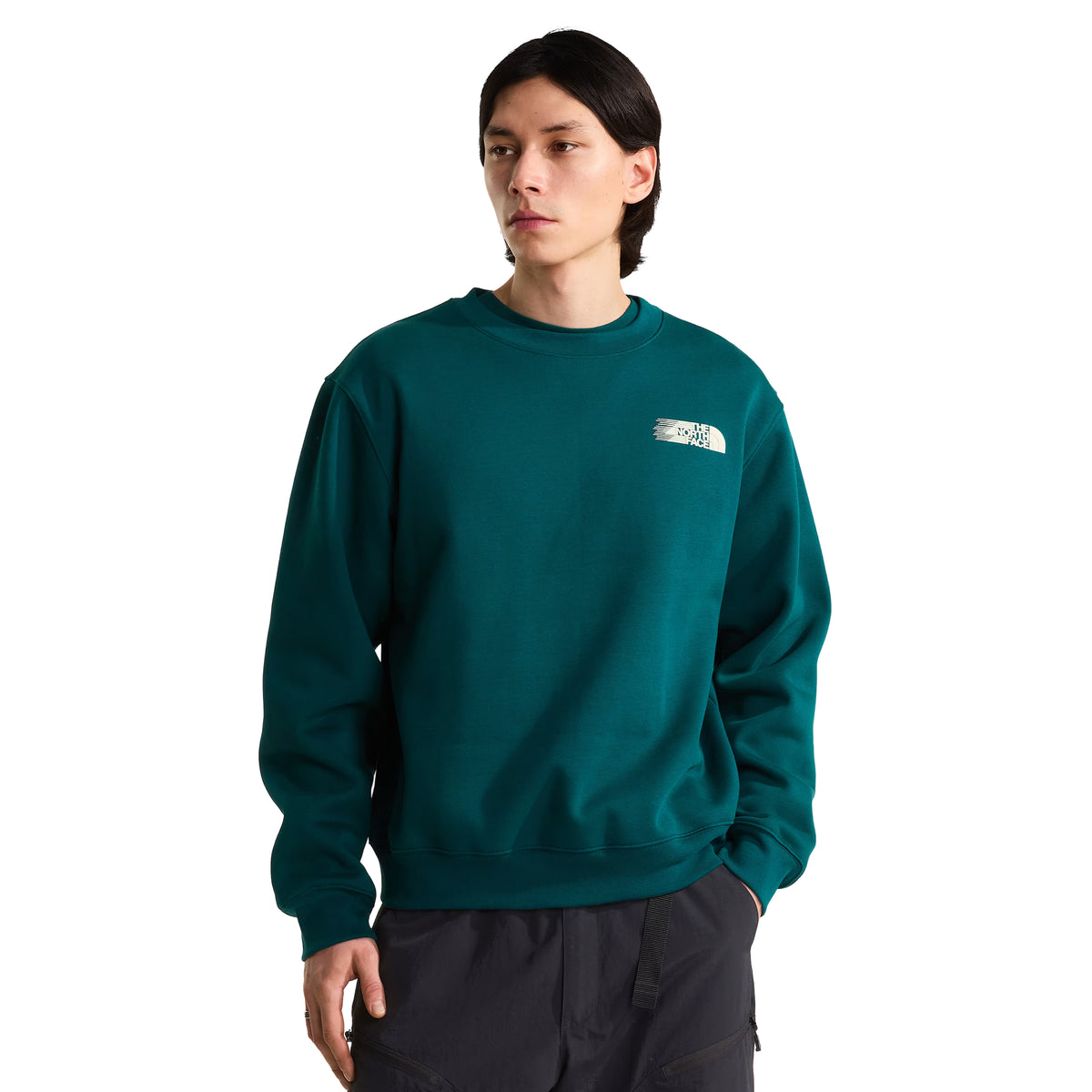 Sweatshirt para homem The North Face Retro Trail Relaxed Crew em Pacific Teal — modelo masculino de frente, meio corpo, malha polar teal, logo The North Face em relevo camurça creme no peito esquerdo sobre pincelada, gola redonda canelada, ombros ligeiramente descaídos, corte relaxed, calças cinzento escuro, fundo branco.