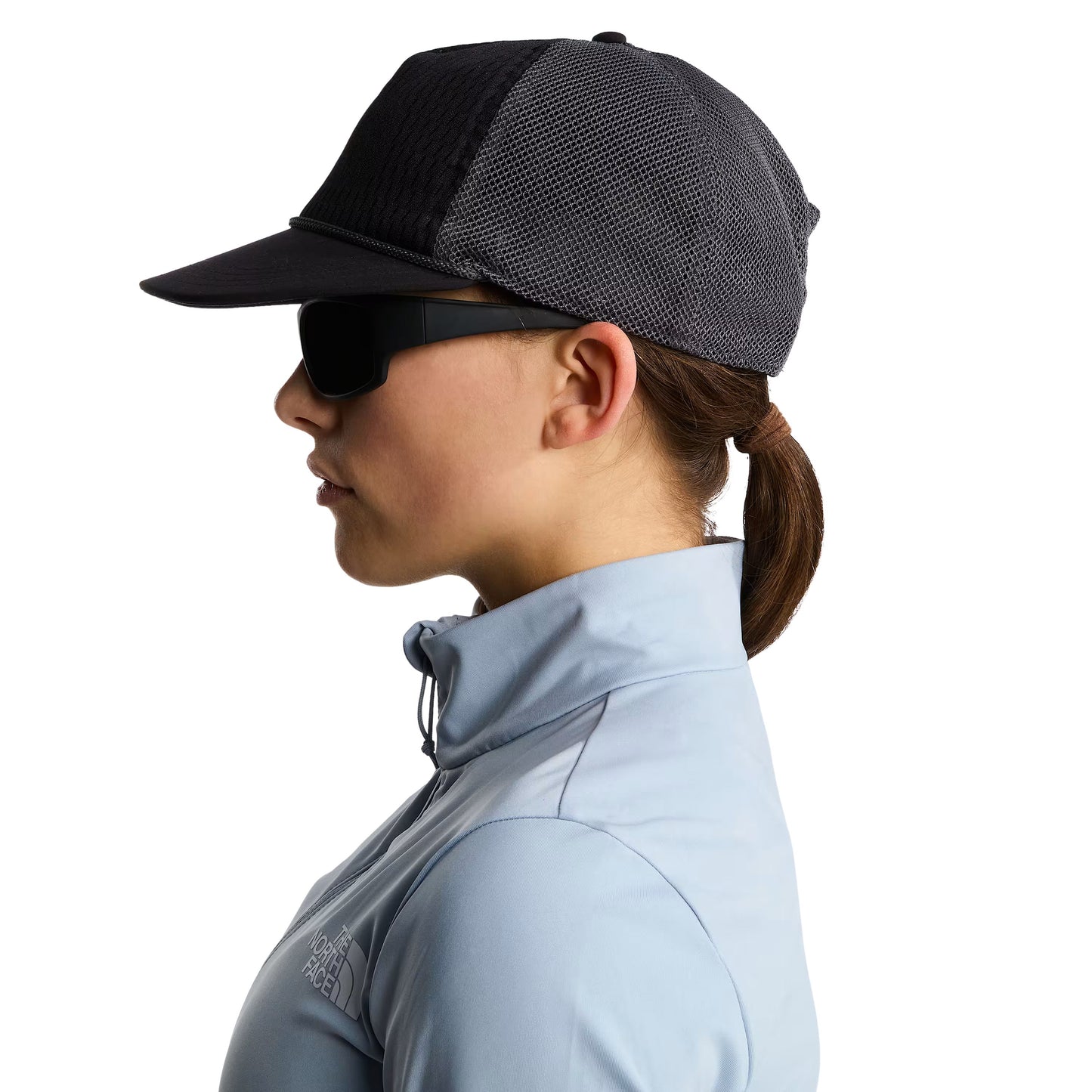 Boné unissexo The North Face Runner Trucker em Preto TNF/Cinza Anthracite. Foto da lateral, na cabeça.