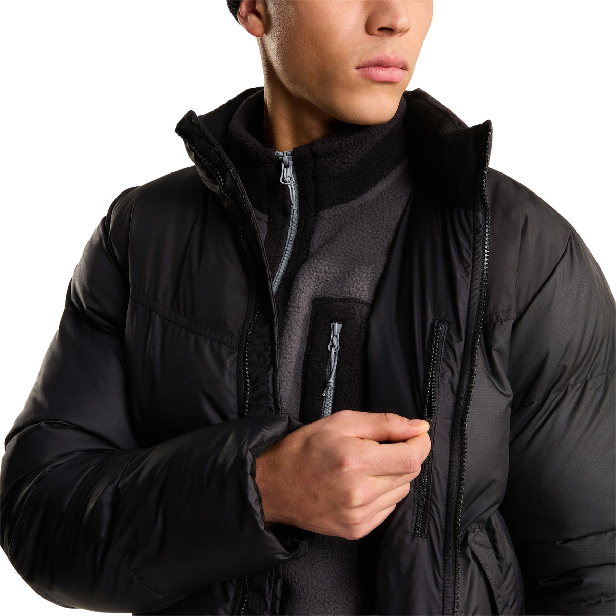 Pormenor do casaco The North Face Saikuru preto aberto, com o modelo a mostrar o bolso interior no peito com fecho de correr.
