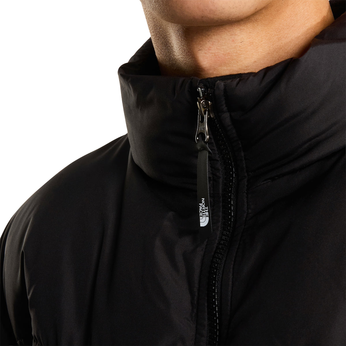 Pormenor da gola alta do casaco The North Face Saikuru preto, com fecho de correr e puxador com o logótipo da marca.