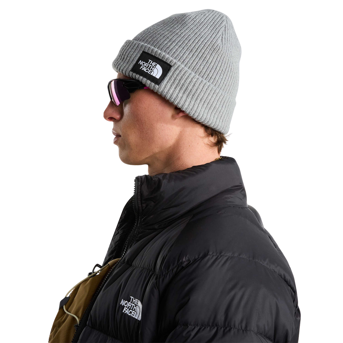 Vista lateral do gorro The North Face Salty Lined cinzento-claro mesclado usado por modelo, com a etiqueta visível na dobra.