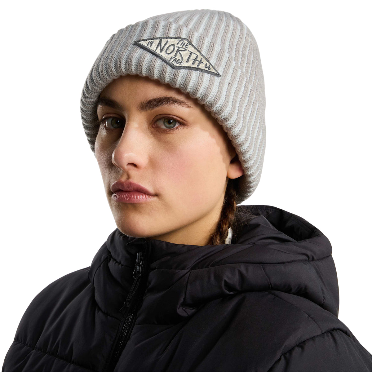 Modelo com gorro The North Face Salty Lined SE Stone Slab e casaco preto, mostrando o ajuste e o emblema na dobra.