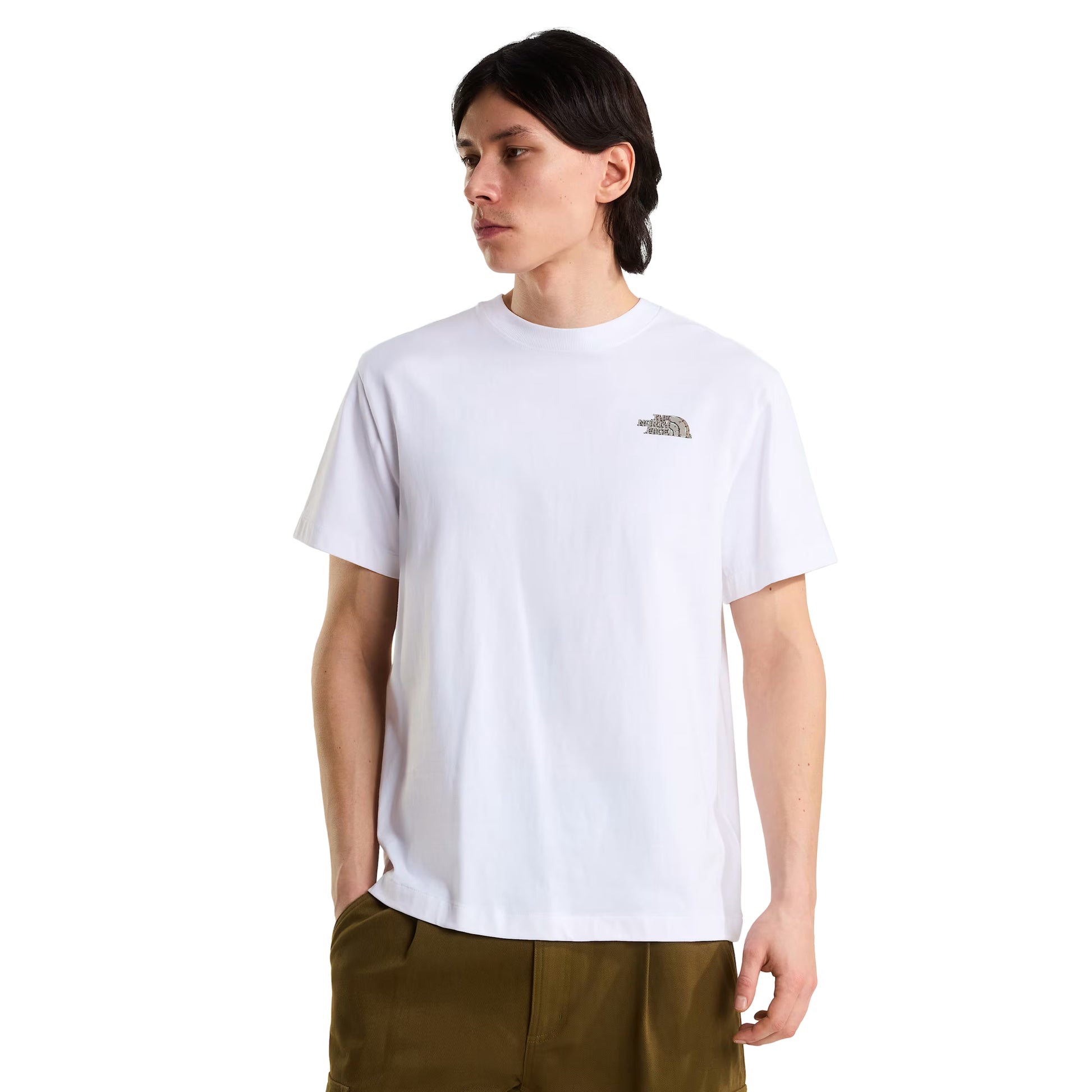 T-Shirt The North Face Stone Logo Relaxed em TNF White — modelo masculino de frente, cabelo comprido escuro, calças cargo verde-oliva, logo TNF Stone em verde musgo/caqui no peito esquerdo e gola redonda visíveis, corte relaxed, fundo branco.