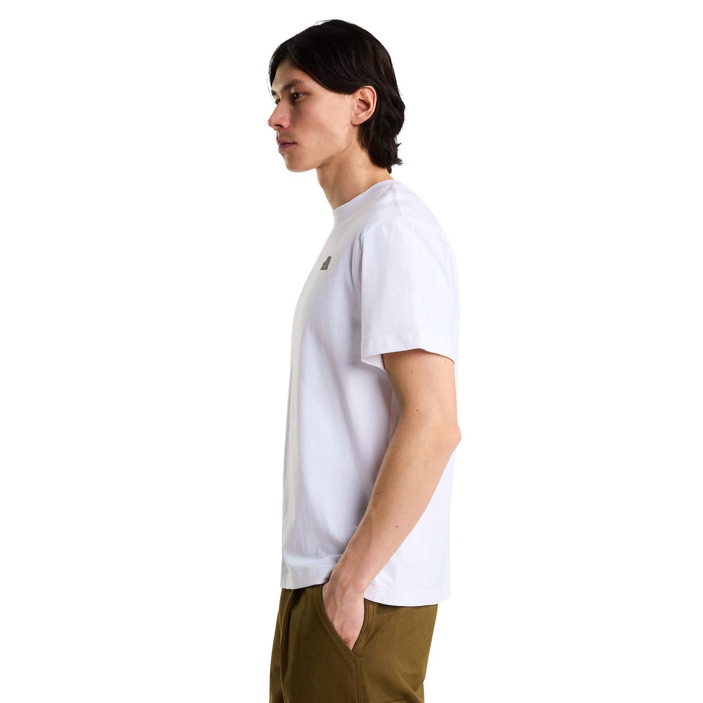 T-Shirt The North Face Stone Logo Relaxed em TNF White — modelo masculino de perfil direito, cabelo comprido escuro, calças cargo verde-oliva, logo TNF Stone parcialmente visível no peito, corte relaxed, fundo branco.
