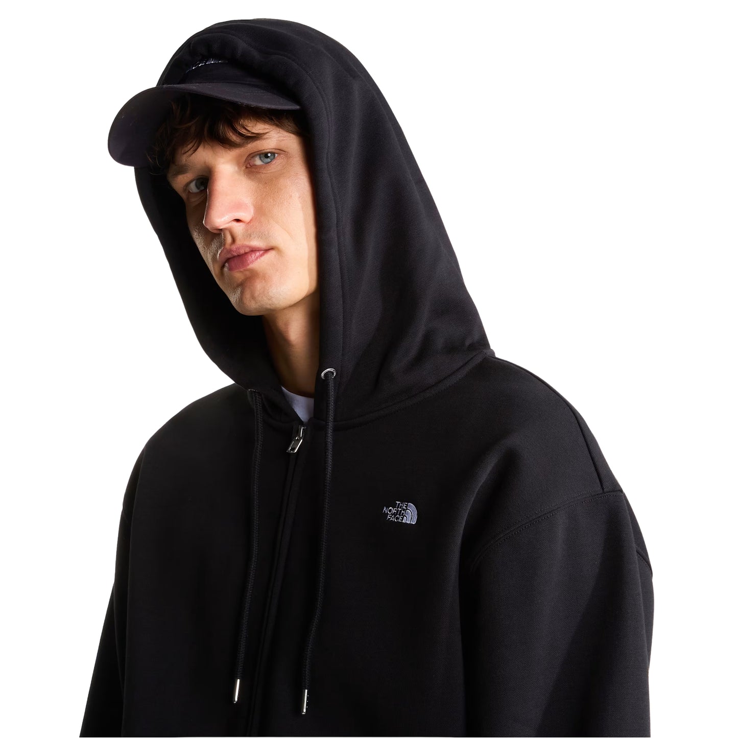 Hoodie The North Face TNF Essential Simple Dome Relaxed Full Zip em TNF Black — detalhe do peito esquerdo, logótipo "The North Face" half-dome bordado em branco em close-up, textura da malha cardada preta 360 g/m² e cordão branco do capuz visíveis, fundo branco.