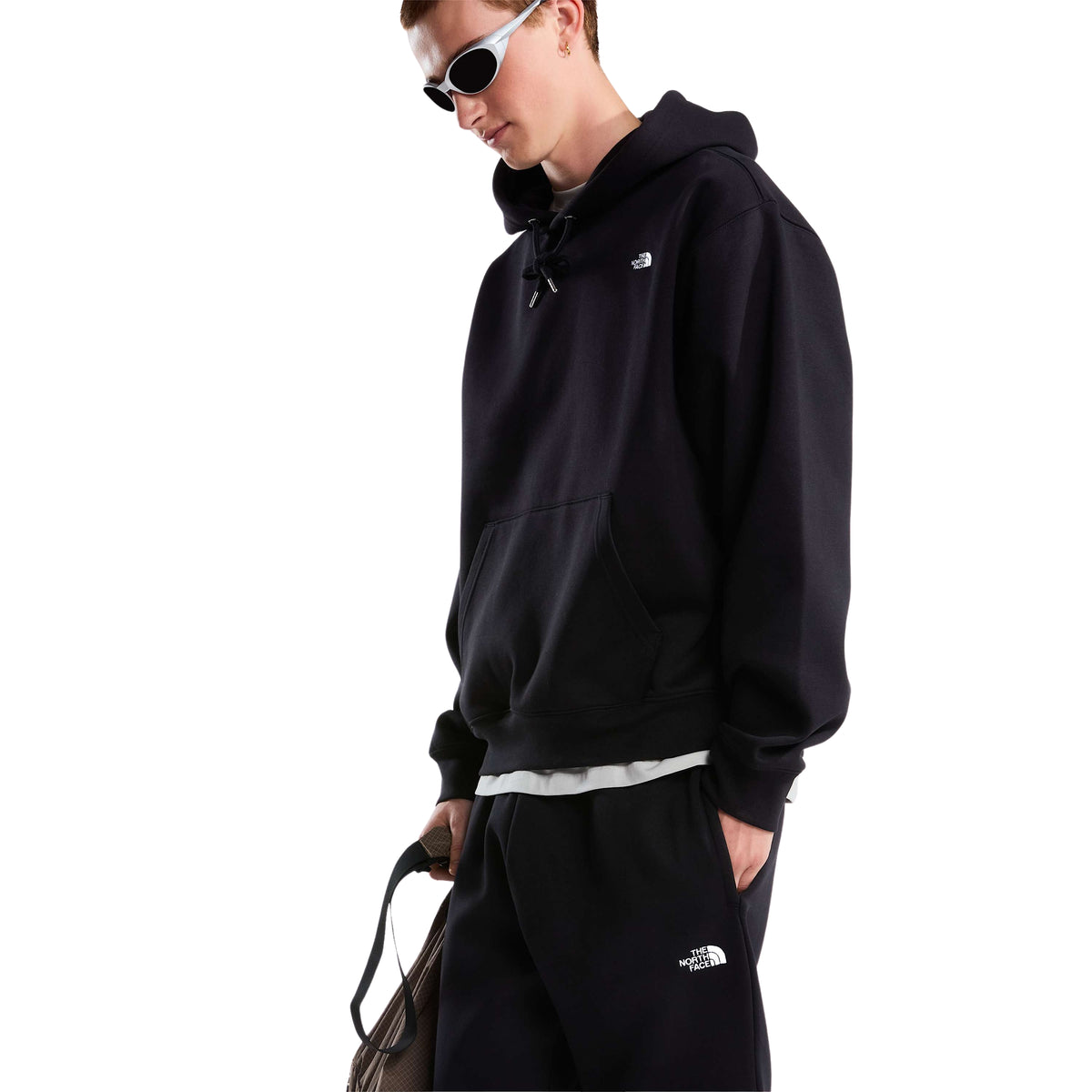Modelo a três quartos com sweat The North Face Essential Simple Dome preta, mostrando o bolso canguru e o logótipo bordado no peito.