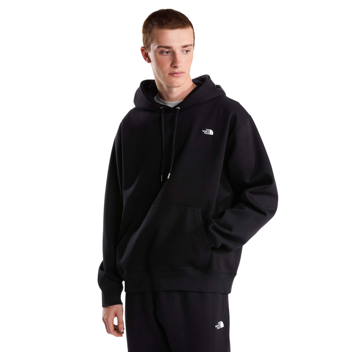 Modelo de frente com sweat com capuz The North Face Essential Simple Dome preta, com bolso canguru e logótipo branco bordado no peito.