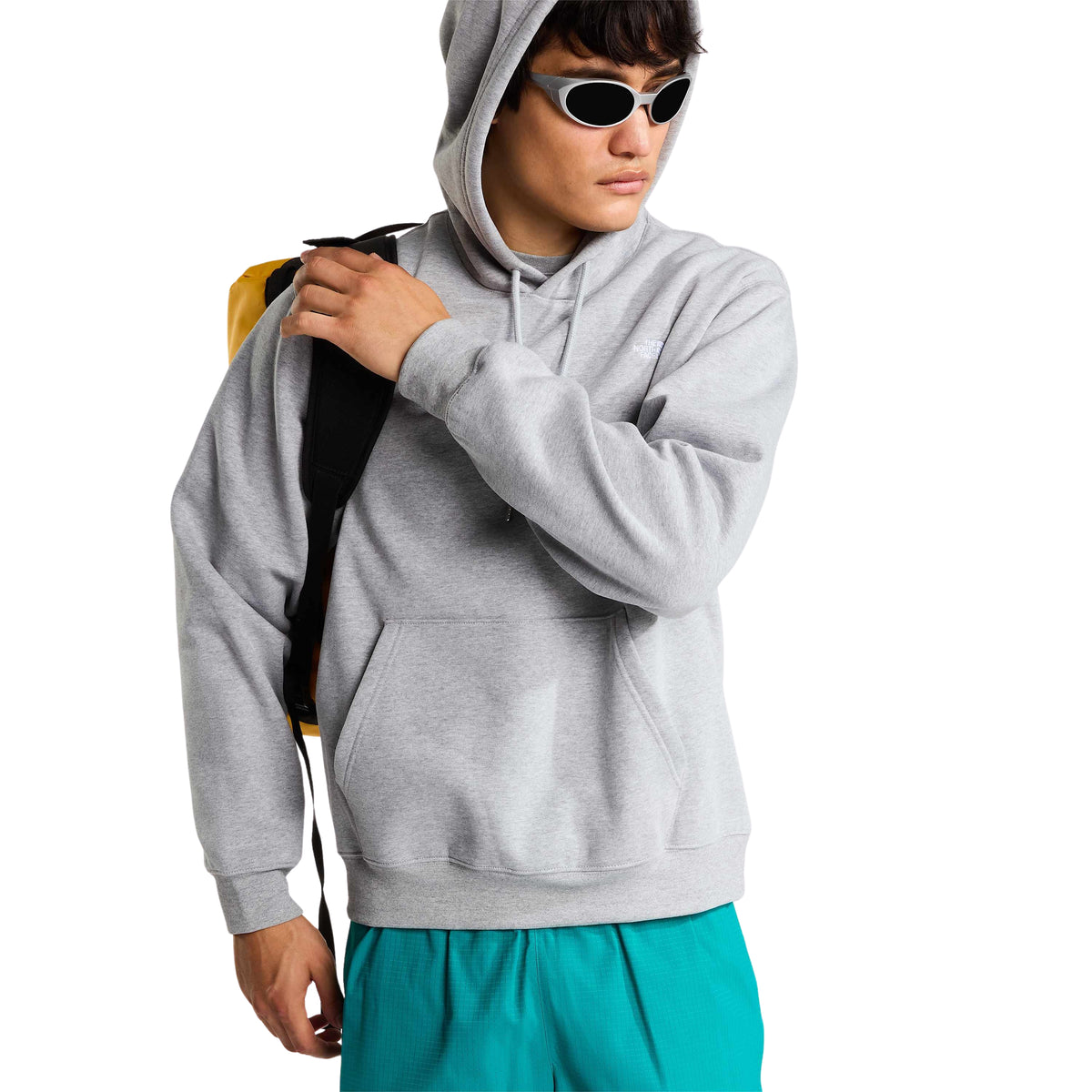 Modelo com sweat The North Face Essential Simple Dome cinza-claro mesclado, óculos de sol e saco ao ombro, mostrando o bolso frontal.