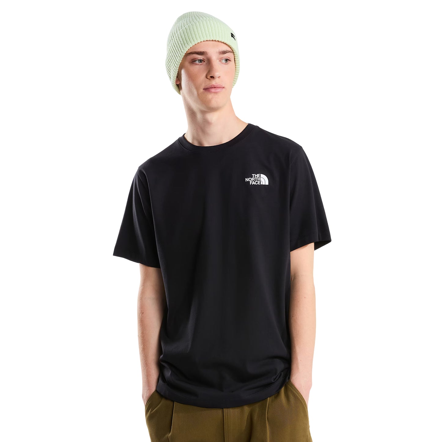 T-Shirt The North Face Vertical Regular em TNF Black — modelo masculino de frente, corpo inteiro, gorro TNF verde-lima, calças cargo bege/cáqui largas e sapatilhas brancas, logo TNF half-dome em branco no peito esquerdo visível, fundo branco.