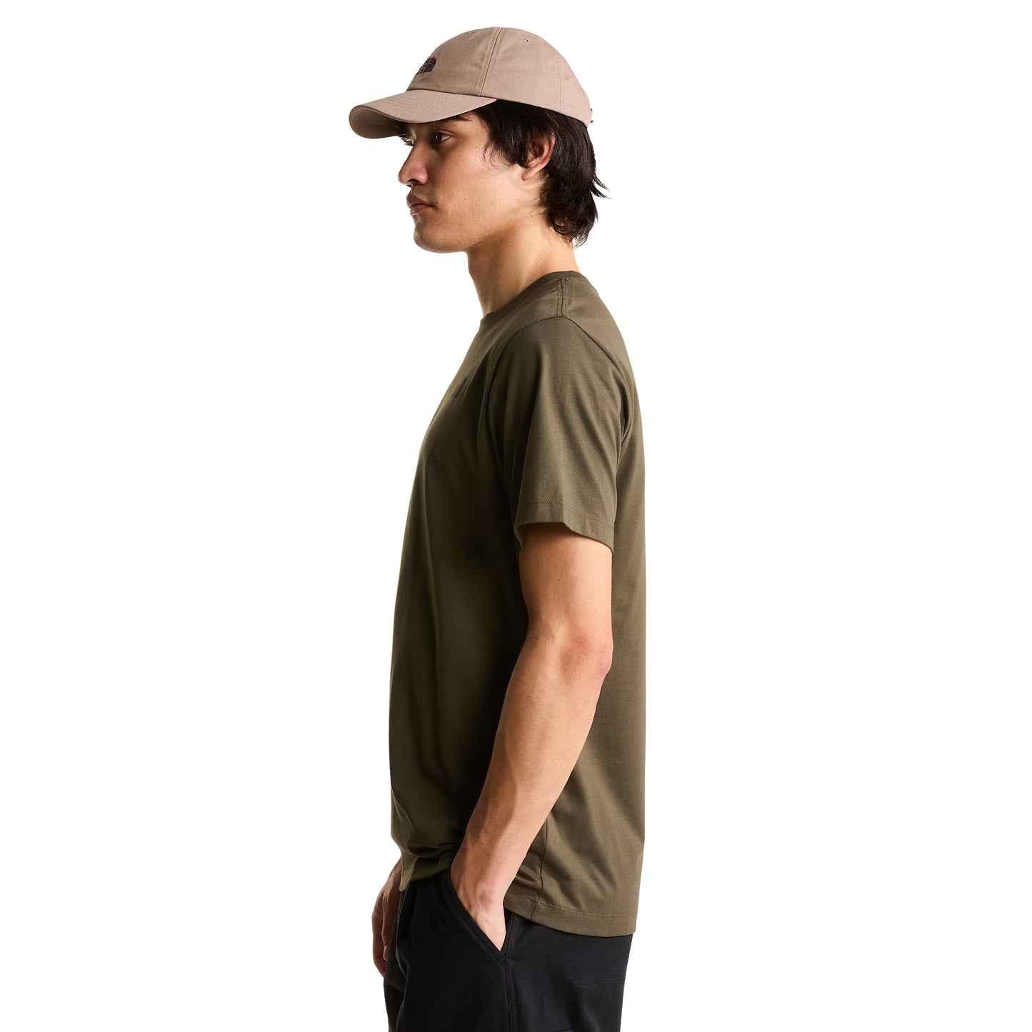 T-Shirt The North Face Yosemite Oak Box NSE Regular em New Taupe Green — modelo masculino de perfil direito, boné TNF bege/taupe, calças cargo pretas, gola canelada e manga curta com corte regular visíveis, fundo branco.