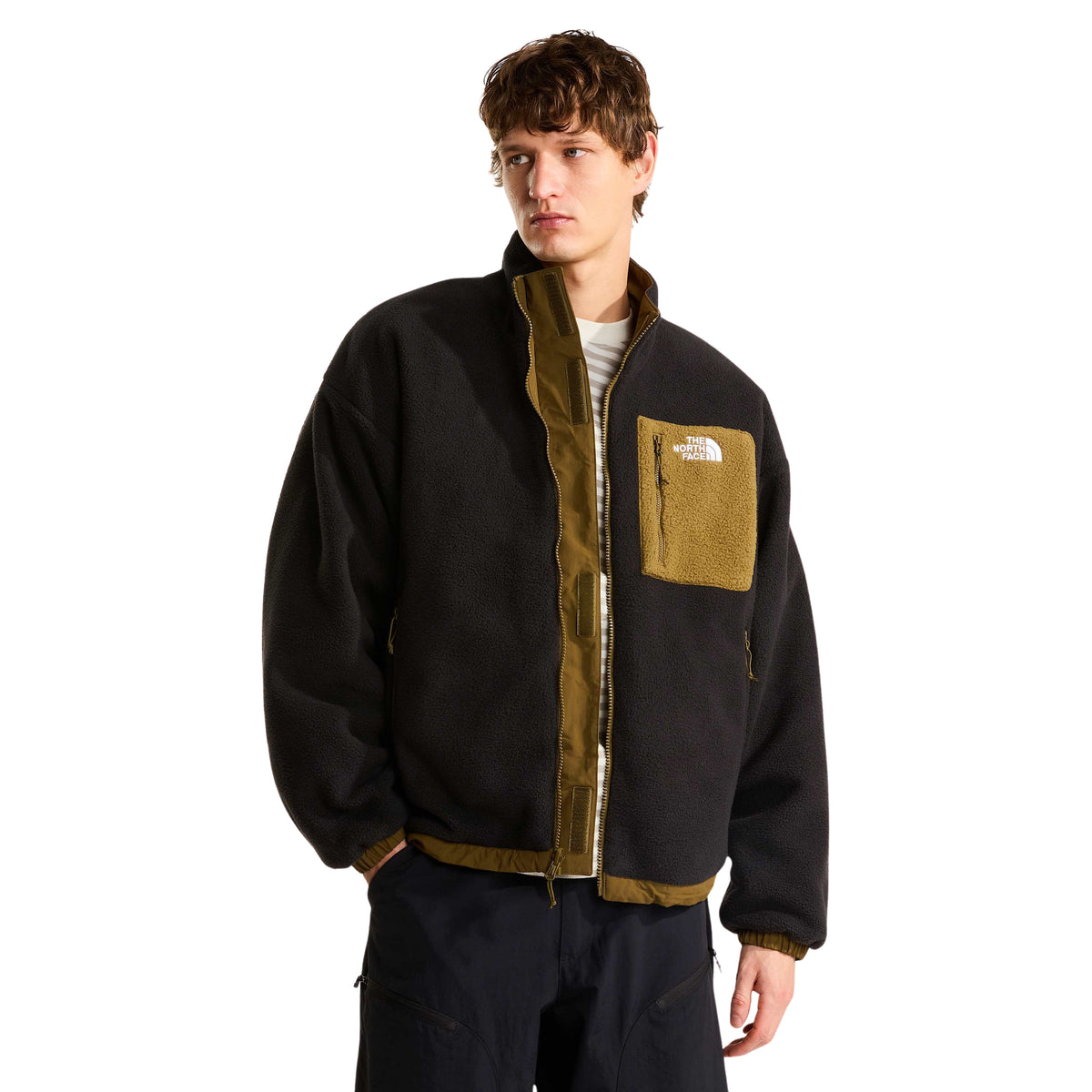 Casaco The North Face Yumiori vestido com o lado polar preto para fora e fecho aberto, mostrando o interior Caraway Seed.