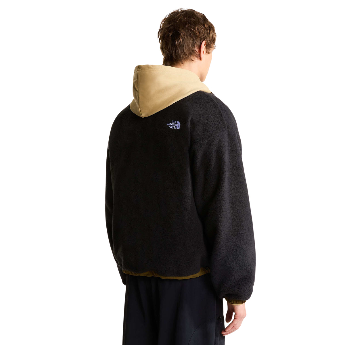 Vista traseira do casaco polar The North Face Yumiori preto vestido, com logótipo branco no ombro direito.