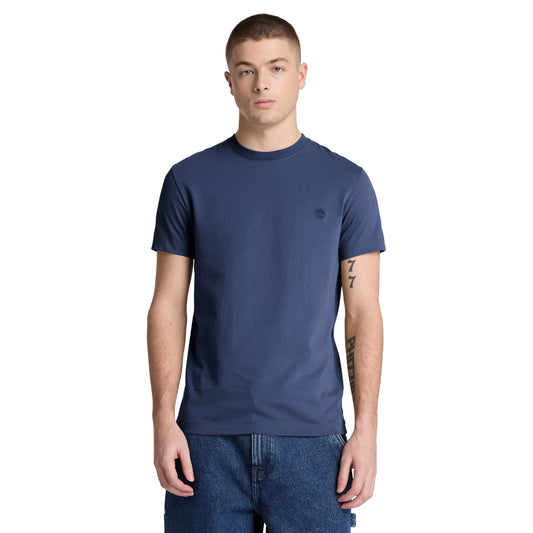 T-shirt Timberland Dunstan River em Naval Academy — vista frontal com modelo, meio corpo, logótipo árvore Timberland bordado em preto tonal no peito esquerdo, gola redonda canelada, corte slim, combinado com calções denim azul.