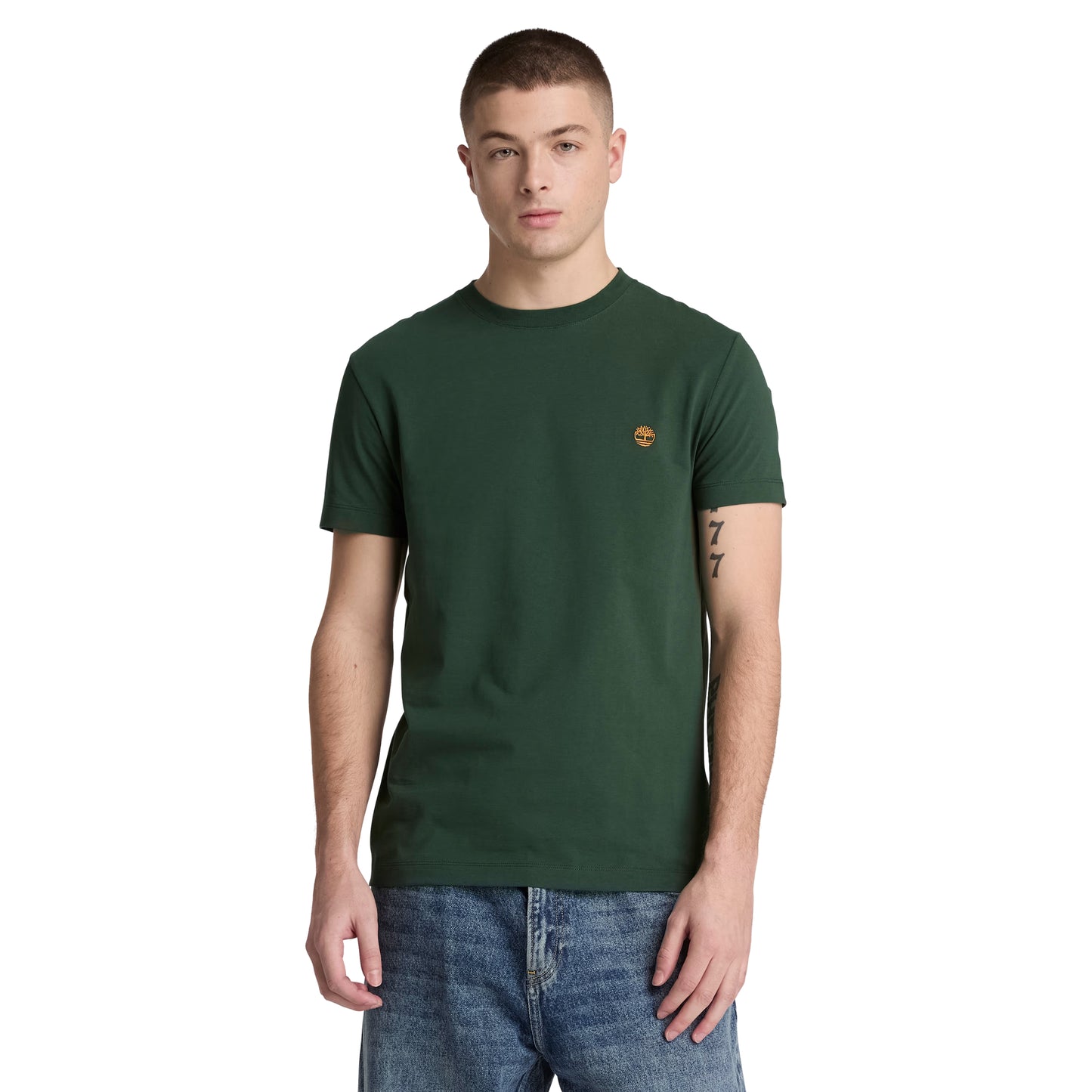 T-shirt Timberland Dunstan River em Sycamore — vista frontal com modelo, meio corpo, logótipo árvore Timberland bordado em laranja no peito esquerdo, gola redonda canelada, corte slim, combinado com calças de ganga azul.