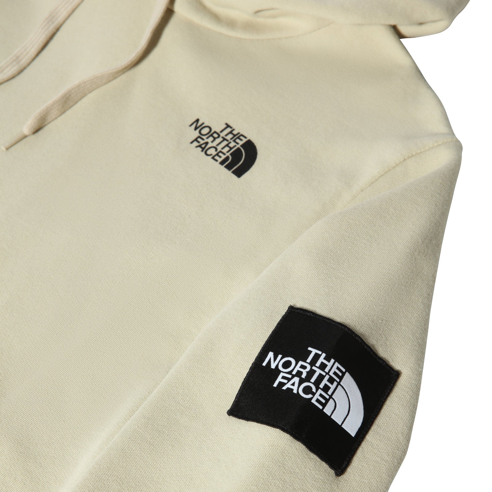 The North Face Galahm Graphic Hoodie Gravel. Foto de detalhe do emblema da Black Box no braço e logo estampado no peito fora de foco.