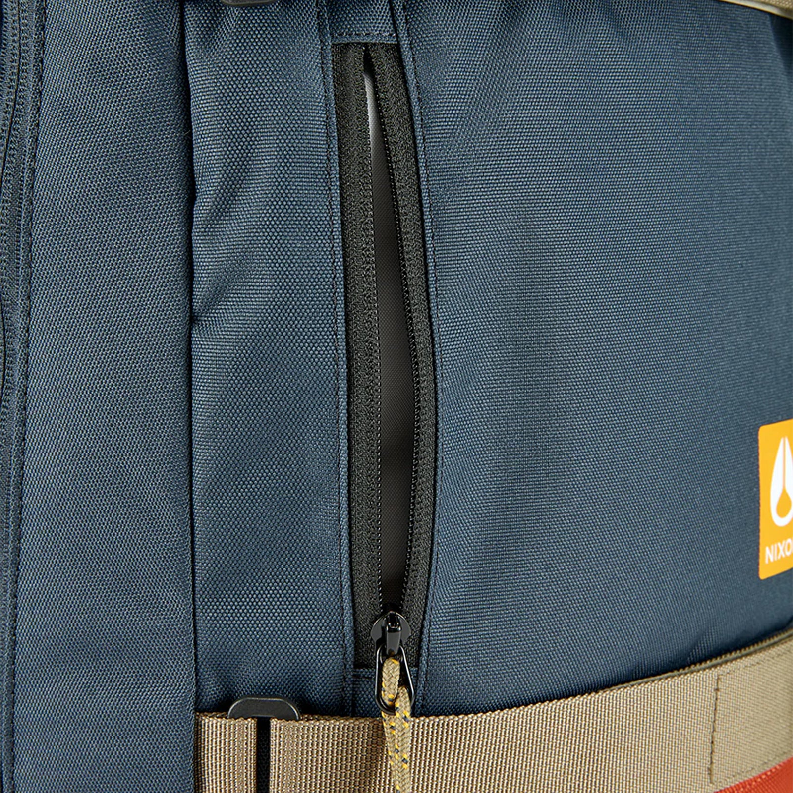 Nixon Gamma 22L Backpack Navy/Multi. Foto de detalhe do fecho da bolsa da frente.