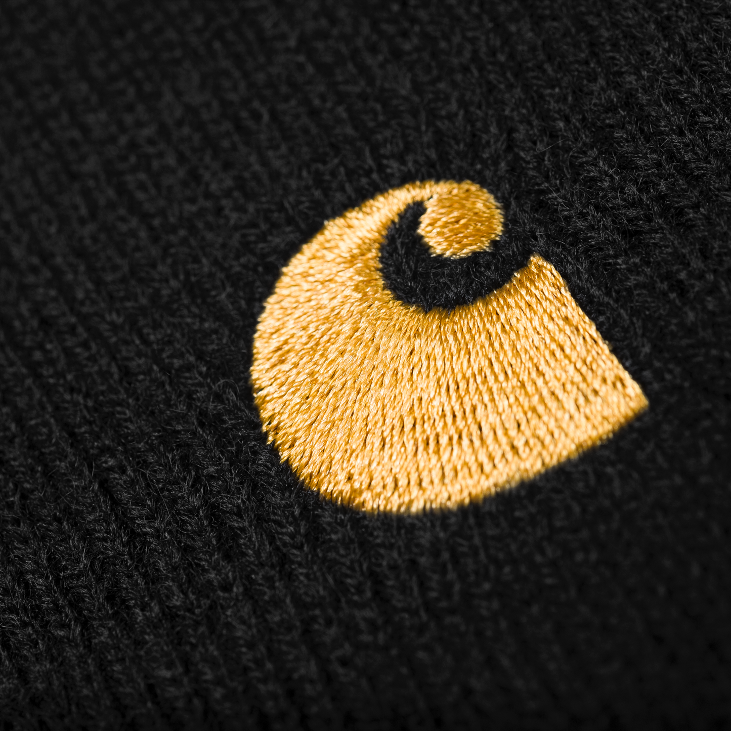 Carhartt WIP Chase Beanie Black/Gold. Foto de detalhe do logotipo bordado.