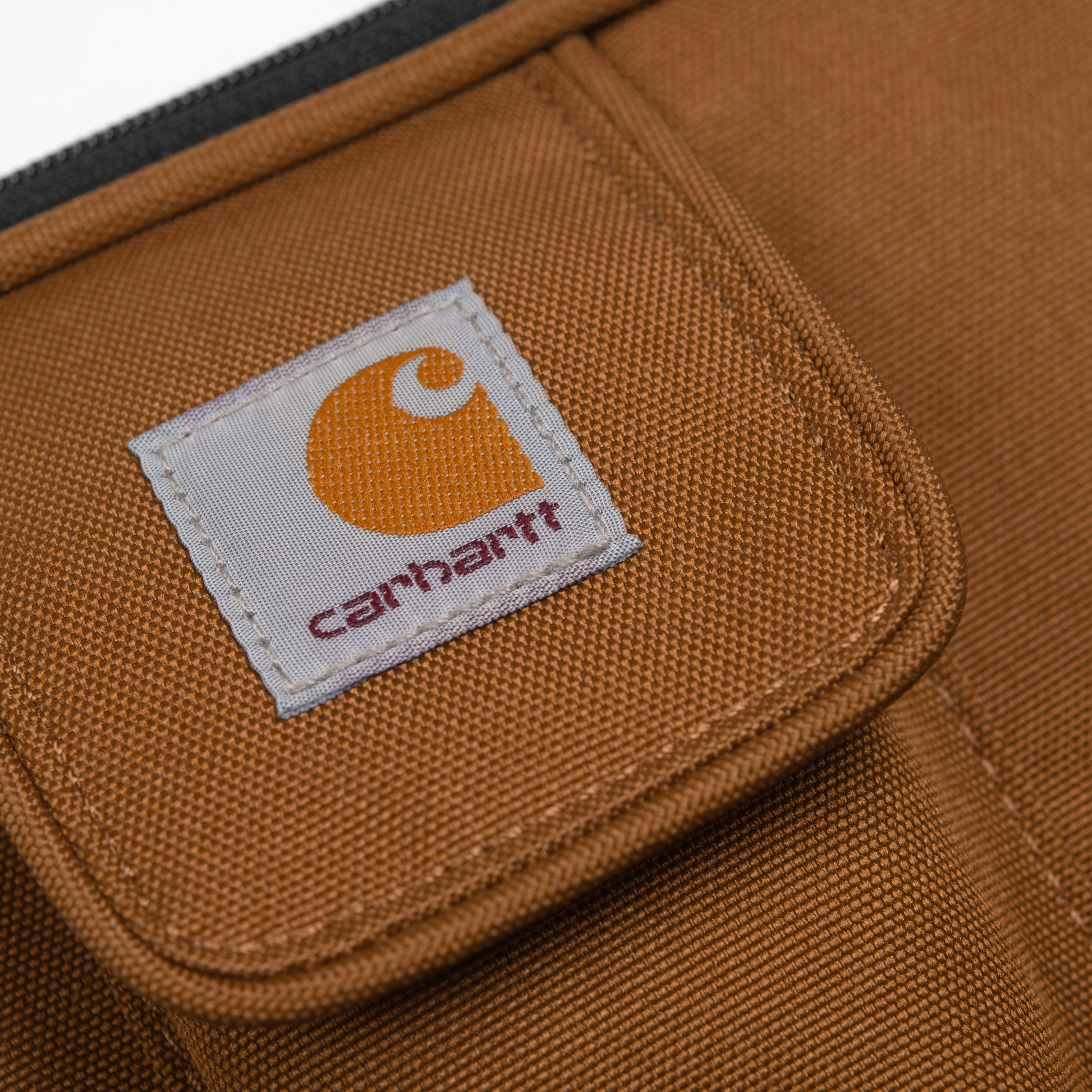 Carhartt WIP Essentials Bag Hamilton Brown. Foto de detalhe do logotipo.