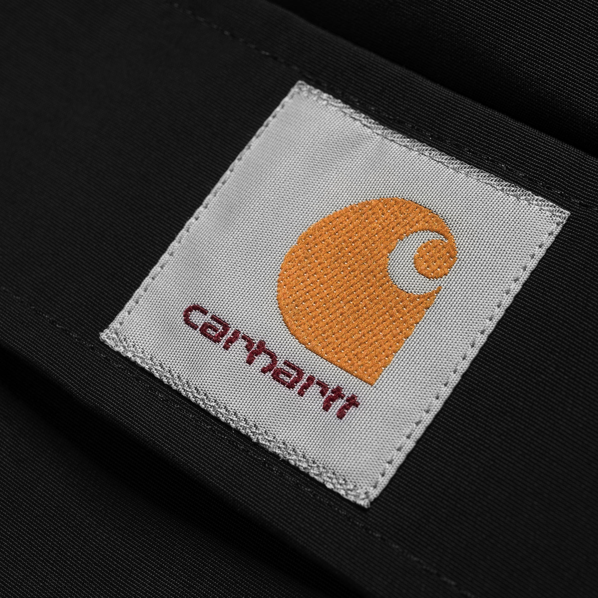 Carhartt WIP Nimbus Pullover em preto. Foto de detalhe do logotipo na frente.